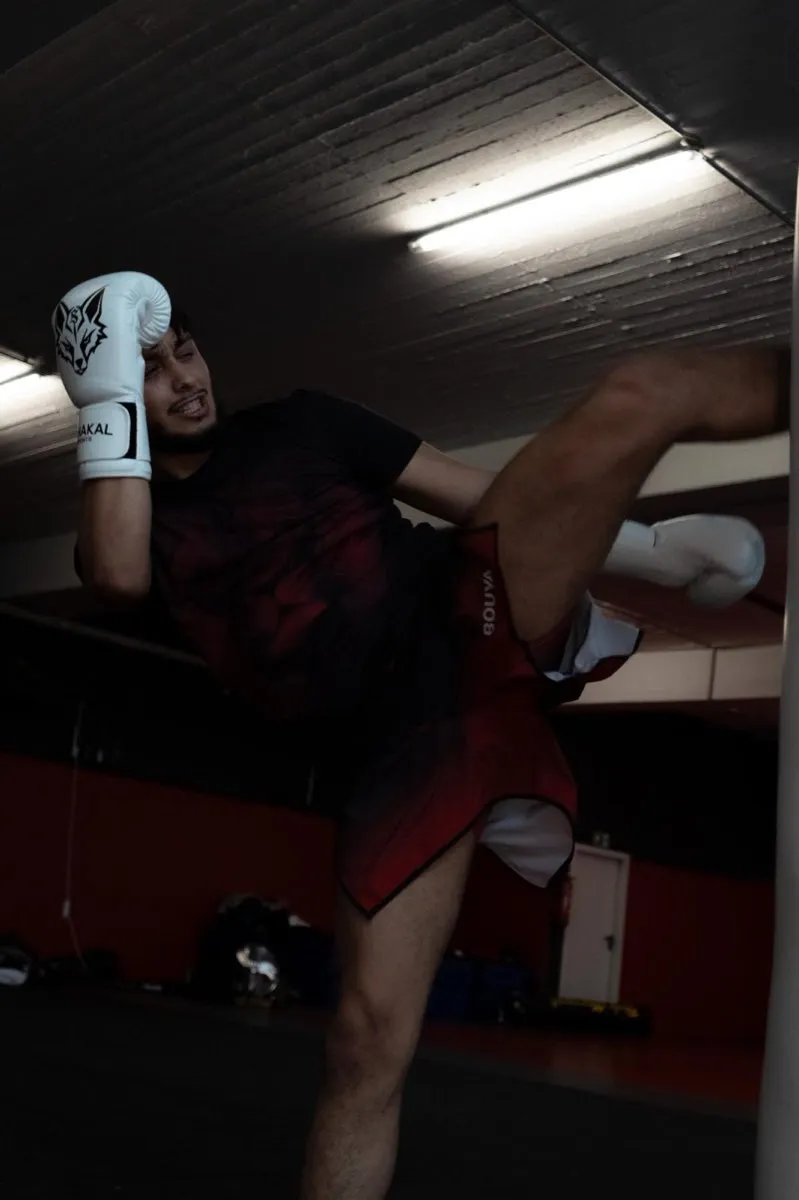 Hoher Kick im Training, graue Schakal-Boxhandschuhe