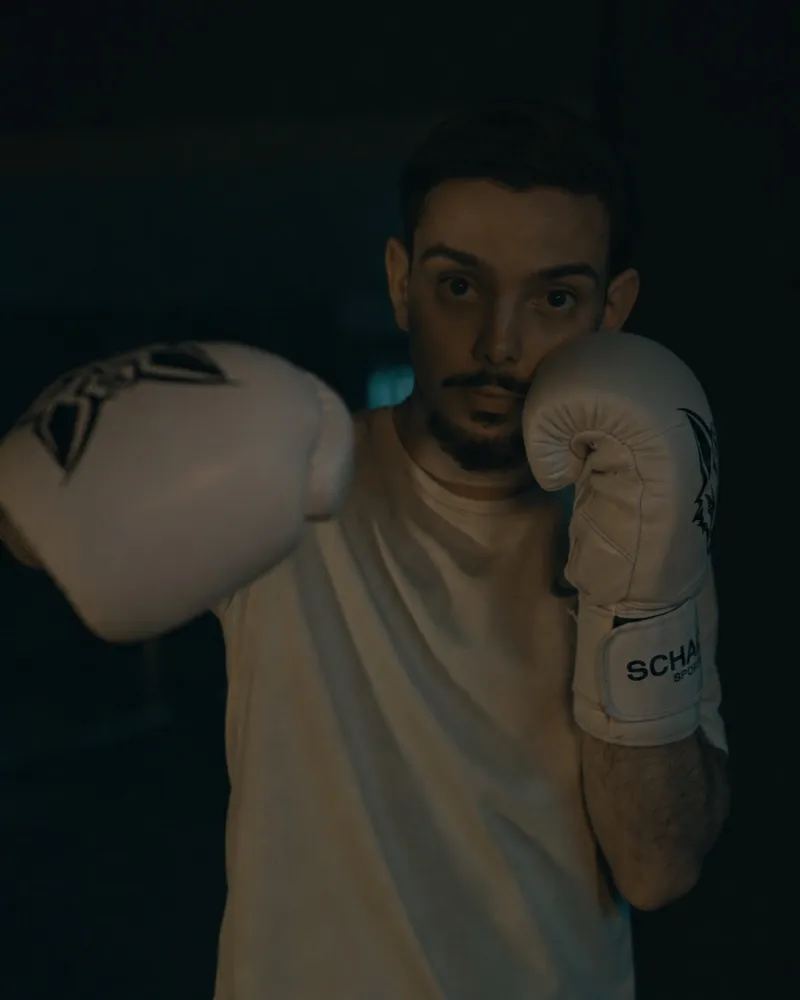 Athlet in Deckung mit weißen Schakal-Boxhandschuhen