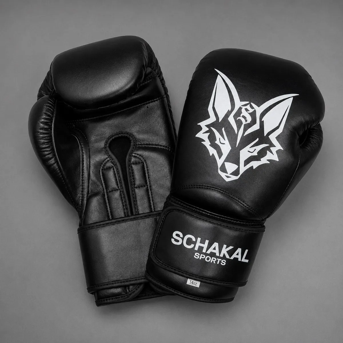 Schwarze Schakal-Boxhandschuhe von oben auf grauem Grund, Innenseite und Handrücken nebeneinander